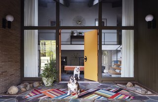 These two orange colors were a popular choice for many midcentury architects and interior designers. Those who want to make a bold design statement with painted walls or doors will love midcentury tangerine shades such as Sherwin Williams’ Carnival (SW 6892) or Orange Fruit (2011-1) by Valspar. If you’re looking for a warm and fun, but more muted orange, try Wright Ochre (FLLW325) from PPG Pittsburgh Paints. This door, still with its Space Age knobs, is painted Flaming Torch by Behr. The brass wallhanging above the landing is by C. Jeré. 