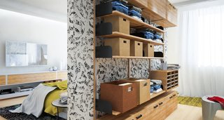 Neatly folded clothes are placed in storage baskets and shelves on this doorless wardrobe system in a small bedroom.