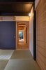 Modern home with Hallway, Light Hardwood Floor, and Rug Floor. The original wooden latticework on the front doors, along with the insect cage-style windows (known as mushiko-mado), timber floors, clay partitions, and baked-tile roofs were retained, while the interiors were updated with modern furnishings and fittings, including minimalist beds and tables made by local artisans. Photo 6 of BenTen Residences