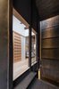Modern home with Hallway and Light Hardwood Floor. A narrow street-level corridor leads to an open-plan dining, kitchen, and living area that looks out to a small Zen courtyard garden at the back of the townhouse. Photo 8 of BenTen Residences