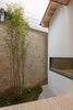 Modern home with Outdoor, Small Patio, Porch, Deck, Side Yard, Trees, Wood Patio, Porch, Deck, and Hardscapes. In the ground level bathroom, guests can soak in a deep bathtub while looking out to views of the courtyard. Photo 9 of BenTen Residences