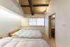 Modern home with Bedroom, Bed, Light Hardwood Floor, and Wall Lighting. The fusuma sliding doors allow for changes in internal spatial configuration, where rooms can be closed off for a more cloistered, private setup, or opened to connect to other functional zones or to let more light in. Photo 12 of BenTen Residences