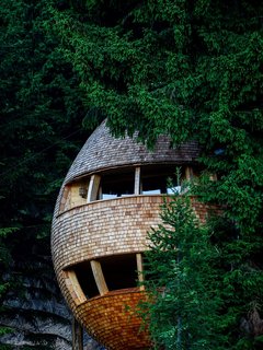 Located in the woods of Malborghetto Valbruna in the Italian Dolomite commune of Tarvisio, this egg-shaped tree house appears to hover in midair like a giant pinecone.