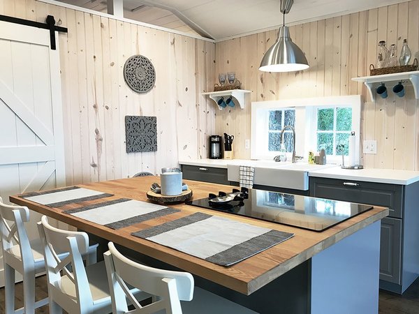 With light wooden walls and a simple gray-and-white color scheme, this four-bedroom cabin from the 1930s in the heart of Osage Beach is full of Scandinavian charm.