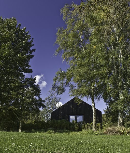 Designed by Copenhagen-based German architect Jan Henrik Jansen, this holiday home on the Danish island of Møn is available for rent through Urlaubsarchitektur. Built with dark timber, the pure form of the structure creates lofty interiors that offer unobstructed views of the surrounding meadows.