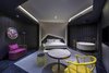 Modern home with Bedroom, Bed, Chair, Ceiling Lighting, Porcelain Tile Floor, and Lamps. International influences can be detected in the bold geometric forms interspersed throughout the establishment including the walnut, marble, and brass interior details that add a continental touch to the lobby and guest rooms. Plus, wild disco colors show up in the fuchsia shower stalls in the en-suite bathrooms, and gold details are abound in the restaurant-bar. Photo 6 of Vue Hotel Hou Hai