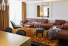 Modern home with Living Room, Sectional, Stools, End Tables, Chair, Pendant Lighting, Ceiling Lighting, and Rug Floor. Splashes of gold from the metallic finishings and plush rugs give the hotel a glamorous Las Vegas-like vibe. Photo 4 of Roomers Munich