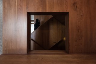 A wooden staircase connects the three levels of the house.