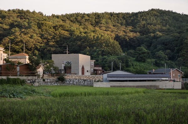 The 1,553-square-foot, two-story brick house is sited on a plain and surrounding by houses with different silhouettes. 