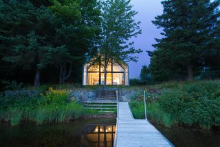 A small porch on the southern facade leads down to the lake.
