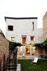 Modern home with Outdoor, Small Patio, Porch, Deck, Back Yard, Stone Fences, Wall, Grass, and Landscape Lighting. A wisteria-shared courtyards and garden with a dining area. Photo 8 of Girona Townhouse