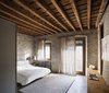 Modern home with Bedroom, Table Lighting, Night Stands, Concrete Floor, Lamps, Bed, Rug Floor, and Wall Lighting. A dialogue between ancient and contemporary can be seen in the bedroom. Photo 10 of Girona Townhouse