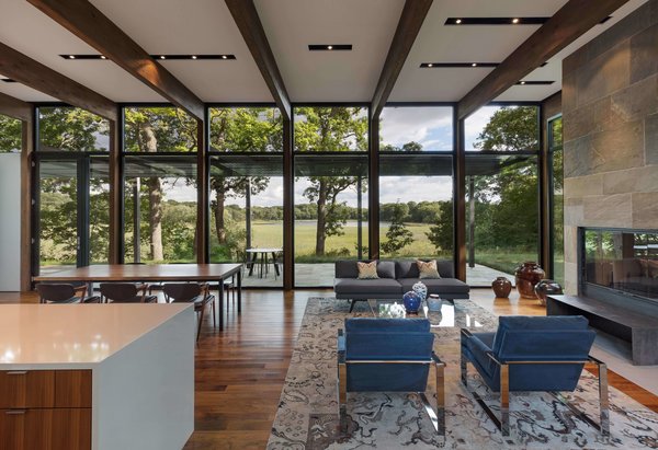 The house is sited on wooded plateau overlooking a wetland and lake beyond.