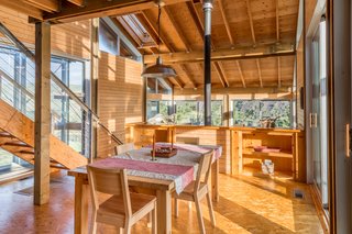 A staircase leads up from the dining and kitchen area to a mezzanine loft bedroom.