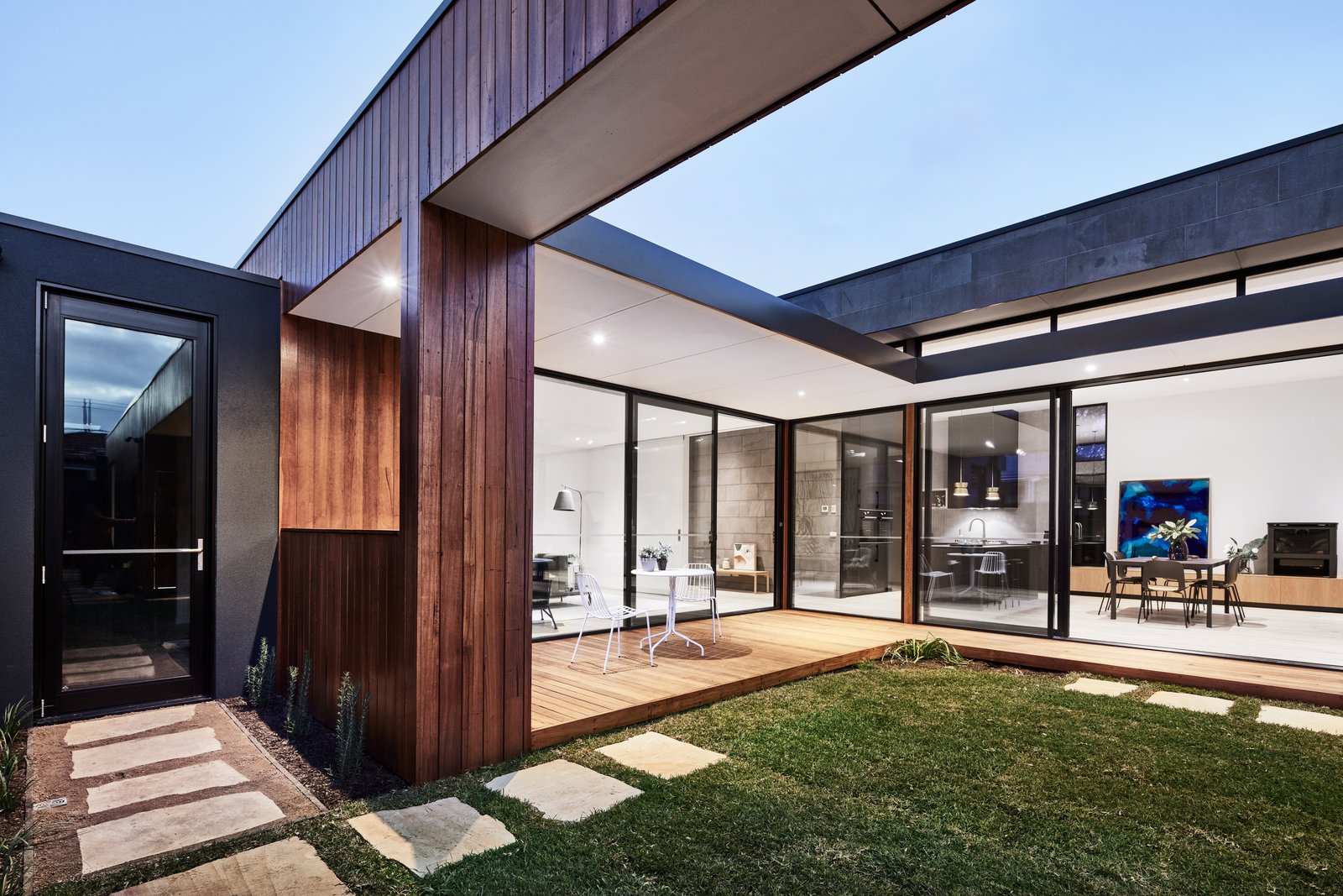 The courtyard includes a decked patio that connects to one of the living rooms. Designed for both work and play, the house features two living rooms, a study area, and a reading nook with floor-to-ceiling bookshelves.
