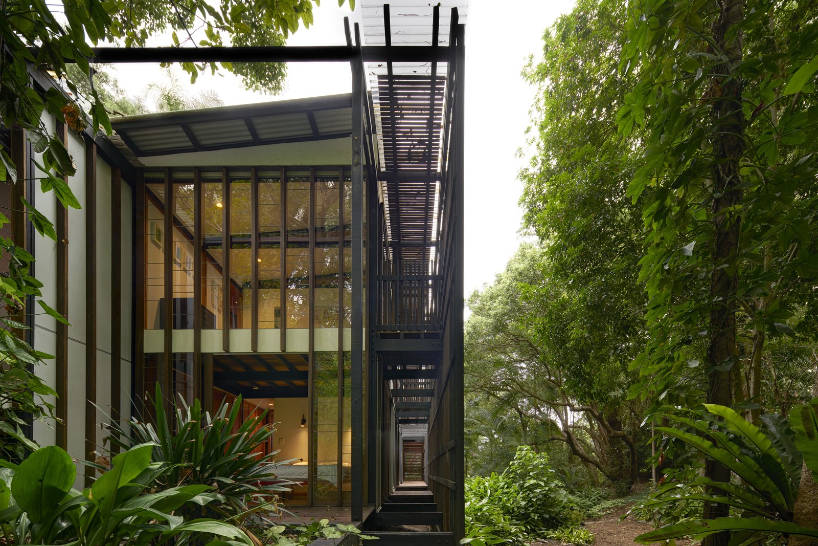 Composed of three, double-storey pavilions punctuated by two voids, and linked by the trellis structure, the interior spaces transition seamlessly to the outdoor spaces.