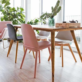 An up-close look at the dining table from Maisons du Monde, a pink dining chair from Habitat, and a black dining chair from Muuto.

