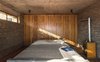 Modern home with Bedroom, Dark Hardwood Floor, Bed, and Track Lighting. Named for its perch in the mountainous region of Kumaon in the North Indian state of Uttarakhand, The Kumaon, which sits about 5,250 feet above sea level in the village of Kasar Devi, is a boutique hotel that enjoys magnificent views of the Indian Himalayas. Designed by Sri Lankan architects Pradeep Kodikara and Jineshi Samaraweera of Colombo–based Zowa Architects, the 10-room hotel is nestled in a sloping, terraced agricultural plot that overlooks uninterrupted views of undulating mountains and valleys. Photo 10 of The Kumaon