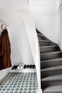 On the first floor, a tiled entrance foyer with storage space for a few jackets and about six pairs of shoes flows towards a master bedroom with a walk-in closet.