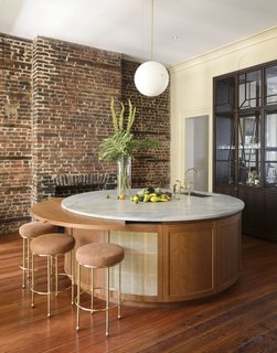 The house features a circular, marble-topped wet bar with Lawson Fenning Orsini stools.