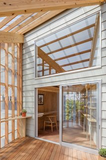 The greenhouse part of the residence is an extended wooden structure clad from top to bottom in acrylic glass.