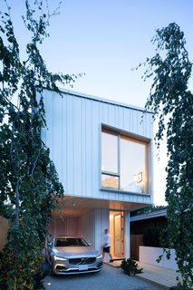 The clean lines of the house’s minimalist façade is accented by standing-seam metal cladding. 

