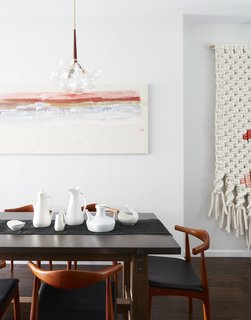 A zinc topped table from Restoration Hardware; lighting fixtures (wrapped in leather) from Pelle; painting on the wall is by Roman painter Giancarlino Benedetti Corcos; large scale wall weaving by Maeve Pacheco; a mix of vintage pottery from Paul McCobb, Ben Seibel, and Eva Zeisel.
