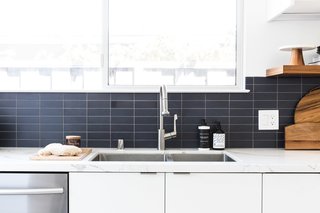 Though the homeowner had a strong preference for a blue backsplash, Hong feared the shade would disrupt the midcentury feel. As a compromise, she opted for a subtle, earthy slate blue in a cool matte finish.   