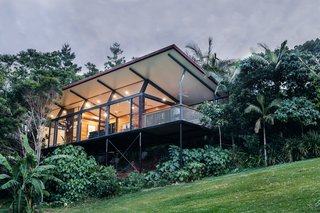 The small studio is sited along a gentle slope and is raised upon steel supports to take in views of the tree canopies.
