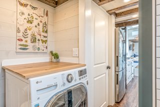 The wooden worktop creates additional usable table space above the washing machine.