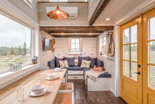 The living area, bathroom, and kitchen are located on the main floor. Two loft bedrooms occupy the upper level.