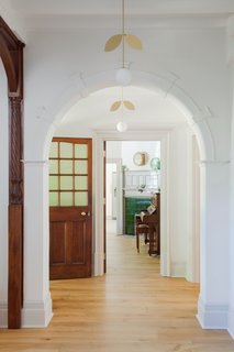 The crisp, white walls contrasts beautifully with the warm, dark wood throughout the house. Here, the hallway lighting is by Areti.