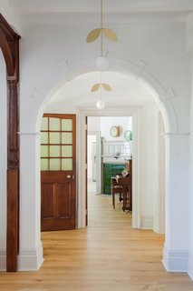 The crisp, white walls contrasts beautifully with the warm, dark wood throughout the house. Here, the hallway lighting is by Areti.

