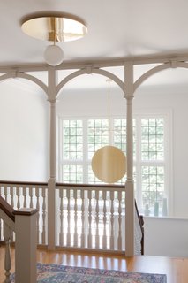 A Pinch pendant light hangs gracefully in the airy hall.

