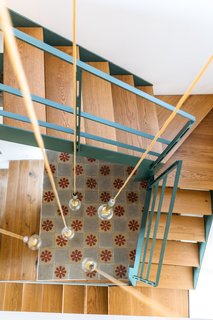 A contemporary iron and wood staircase leads up to a small loft where the owners can relax and listen to music.  