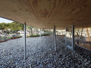 The upper volume is supported by slender, branch-like metal posts.