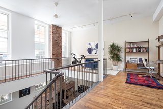 The wraparound mezzanine has a massive skylight. This space could be used for a variety of purposes, including being converted into a fourth bedroom.