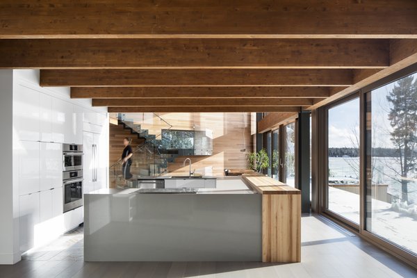 Exposed beams run from the inside to the outside, directing views towards the lake. 