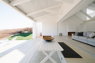 Open-air patios are located at all four corners of the house, and three bedrooms are set along three sides of the square.