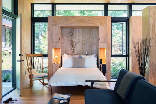 In this living area, a built-in Murphy bed can be pulled down to create a flexible sleeping area when needed. This Murphy bed incorporates two small bedside nooks with built-in lighting.