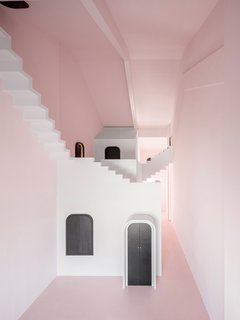 Dream is painted a soft pink. All the "mundane" components of daily life, such as lighting fixtures and electronic appliances, have been concealed behind a series of black doors. 