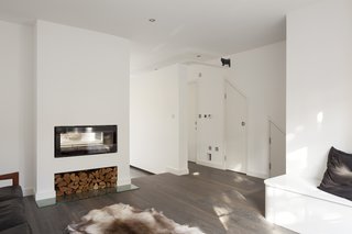 Living Room, Standard Layout Fireplace, Wood Burning Fireplace, Bench, Recessed Lighting, and Medium Hardwood Floor This walkway leads across the hall and through a passageway to a room where the cats’ litter tray is kept.