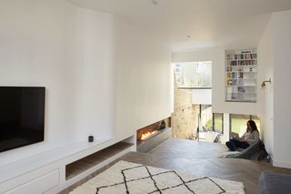 Maya Carni relaxing near the fireplace in the stepped-down lounge area.