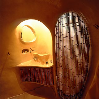 The bathroom features a sculptural sink and shower.