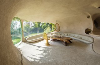 The living room features a bench filled with small polyurethane balls that conform to the shape and weight of the sitter.