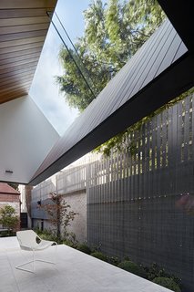 A breezy patio features a pitched roof that offers a view of the sky.