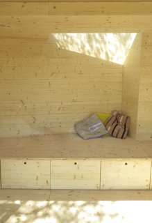 A built-in bench seat with a skylight above it, and large drawers beneath provides a cozy area for reading in the sunlight, as well as storage space.