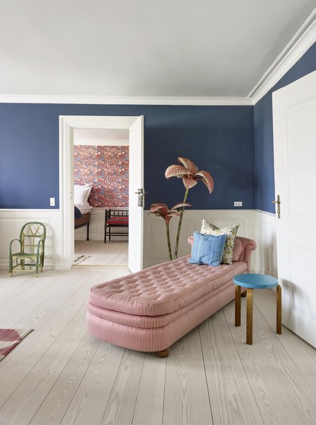 A vintage Svenkt Tenn daybed by Josef Frank, Alvar Aalto stool, and Artek French vintage floor lamp create a colorful nook for lounging.