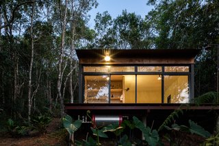 The fully glazed facade physically and visually connects the interiors to the natural environment.