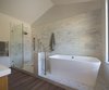 Modern home with Front Yard, Wire Fences, Wall, Gardens, Metal Patio, Porch, Deck, Large Patio, Porch, Deck, Wood Patio, Porch, Deck, Closet Storage Type, Under Stairs Storage Type, Wood Tread, Metal Railing, Pendant Lighting, Medium Hardwood Floor, Wood Burning Fireplace, Picture Window Type, Wood, Bench, and Bath Room. Master Bathroom shower and tub Photo 11 of Modern Vineyard Farmhouse